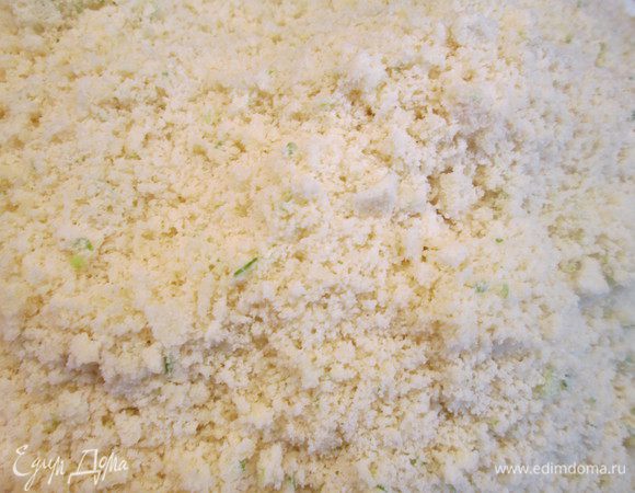 В блендер кладем сначала все сухие ингредиенты: муку, манку, соль, соду, разрыхлитель.  Перемешиваем и добавляем лук, сыр и чеснок. Снова перемешиваем и кладем кубики масла, взбиваем в пульсовом режиме до мелкой крошки. Теперь добавляем пармезан и снова взбиваем в том же режиме.