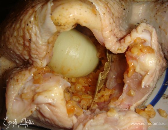 Часть булгура вложить в курицу, положить очищенный лук, лавровый лист, нафаршировать до конца курицу.