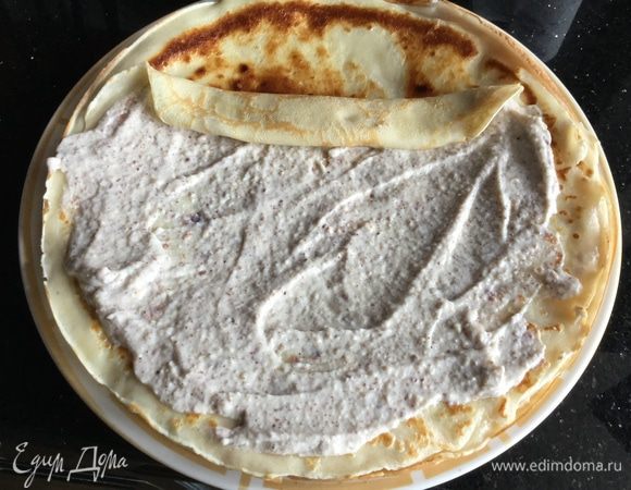 Смажьте каждый блин кремом и сверните в трубочку.