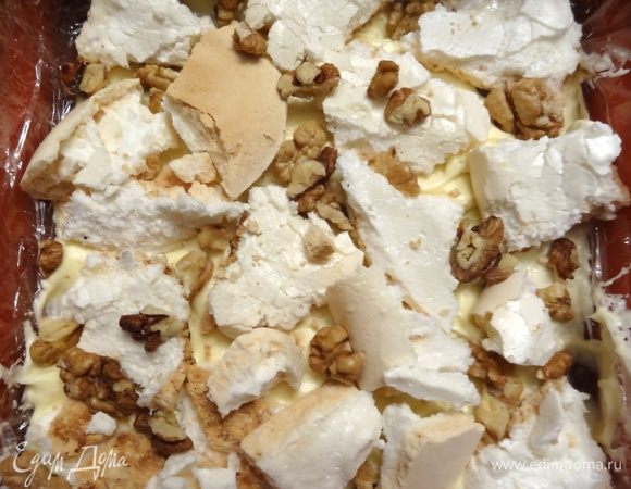 Форму выстелить пищевой пленкой. На дно выложить 3 — 4 ложки крема (1/4 часть), сверху —  кусочки меренги (1/3 часть) и щедро посыпать орехами. Чередовать слои, последний слой — крем. Поставить торт в морозильник на несколько часов.