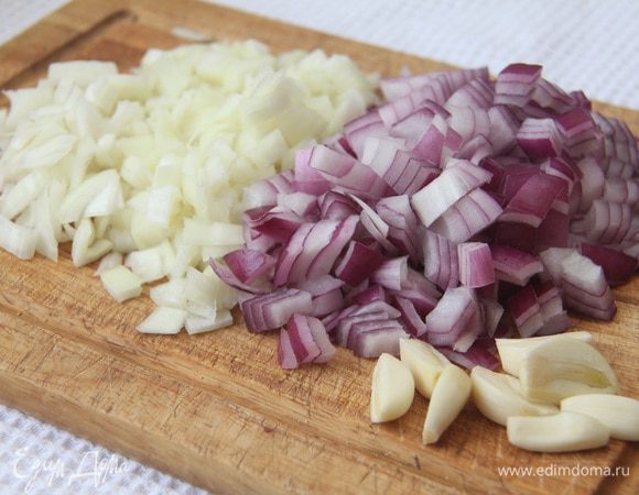 Порубить кубиком лук, чеснок разрезать вдоль пополам.