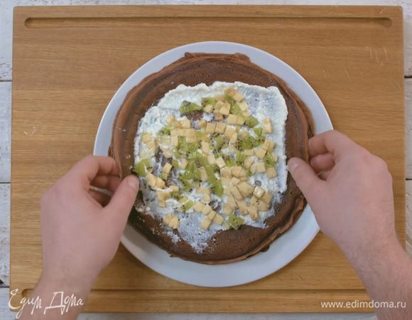 Творог распределить на блинчиках тонким слоем. Сверху выложить фрукты.