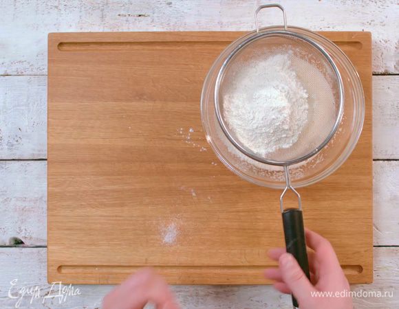 Постепенно через сито всыпать муку с содой. 