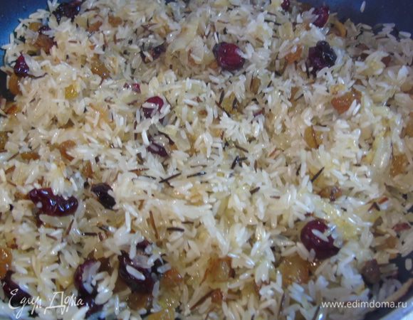 В сковороду к жареному луку добавляем рис, чернику сушеную (у меня изюм и клюква), корицу в палочках и, посолив и поперчив по вкусу, обжариваем немного, все время помешивая.