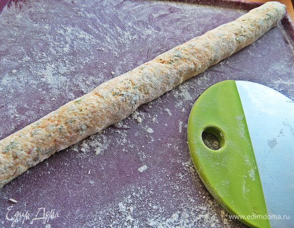 Насыпать на поверхность муку и раскатать на ней тесто в колбаску.