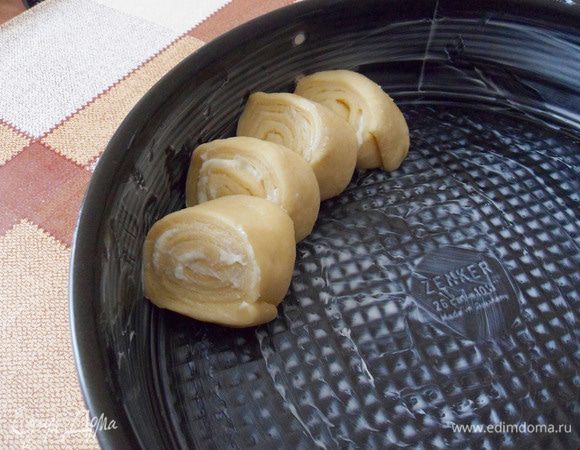 Круглую форму смазать маслом, выложить кусочки немного наклонно, захватывая каждый предыдущий кусочек на половину.