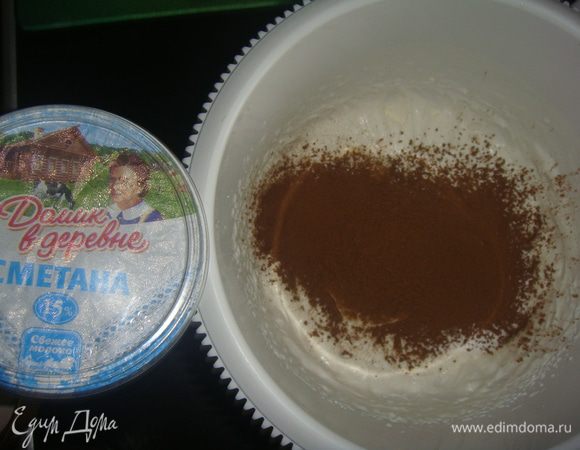 К взбитым сливкам добавить сметану, просеять сахарную пудру и какао. Взбить все в течение 5 минут.