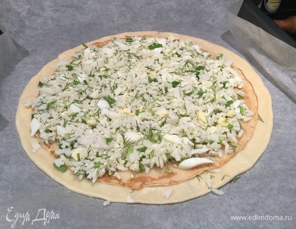 Положите на тесто блин, сверху выложите половину рисовой начинки, разровняйте и накройте блином.