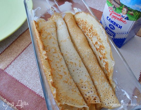 Выложить в форму первым рядом блины с яблочной начинкой.