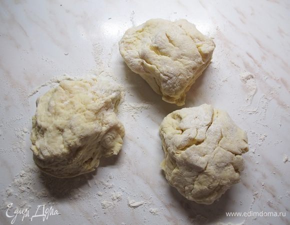 Муку просеять, смешать с содой, постепенно подсыпая к масляно-сметанной смеси, замесить мягкое тесто. Разделить на три части.