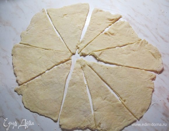 Доску припылить мукой. Каждый кусочек раскатать в круг, разделить на 8 — 10 секторов.