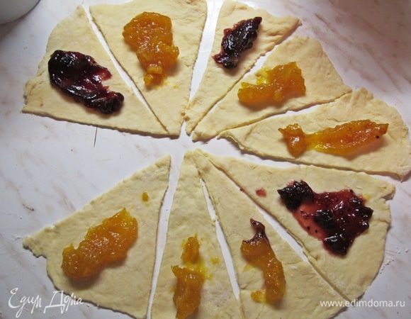 На каждый кусочек выложить джем и свернуть, начиная с широкого конца.