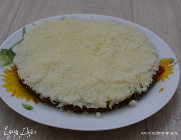 Собираем торт. Нижний корж обильно поливаем пропиткой. Сверху ровным слоем распределить кокосовую массу. Покрыть начинку вторым коржом, который тоже не забываем тщательно пропитать.