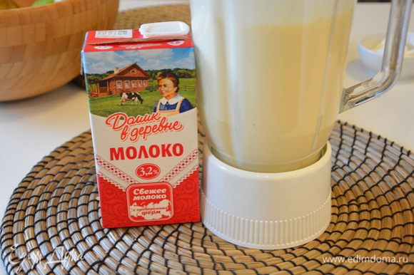 Добавить молоко «Домик в деревне» комнатной температуры и просеянную муку, взбить блендером, чтобы не было комочков.