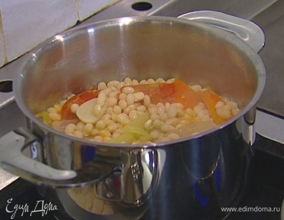 Фасоль залить водой согласно инструкции на упаковке, добавить помидор целиком, очищенные лук и чеснок, лавровый лист и отварить до готовности без добавления соли, затем овощи и лавровый лист удалить.