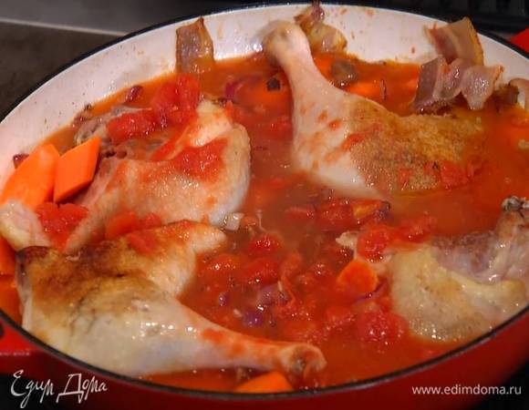 Добавить консервированные помидоры и белое вино, все перемешать и дать алкоголю выпариться, затем влить горячий куриный бульон, так чтобы ножки были покрыты, накрыть сковороду крышкой и томить на медленном огне 2 часа, пока мясо не будет отходить от косточек.