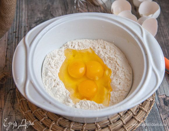 Просеять муку в миску, сделать углубление в центре. Добавить яйца.
