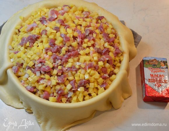 Смазать форму (28 см) маслом. Начинку посолить, поперчить перемешать. Разложить круг из теста в форму так, чтобы свисали края. По краям можно подложить полотенце, чтобы тесто не порвалось. Выложить начинку.