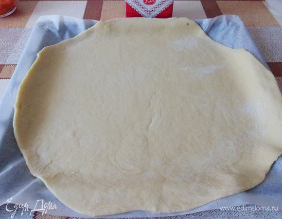 Раскатать в пласт толщиной около 0,6 см. Перенести раскатанное тесто на противень застеленный бумагой для выпечки.