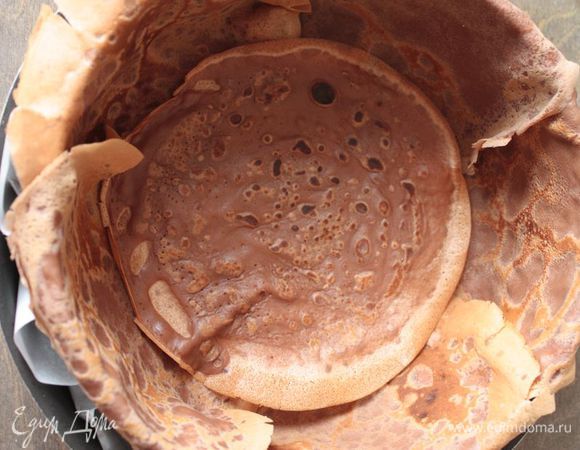 И пока получившийся мусс не загустел, собираем торт! Берем съемную форму, ставим ее на бумагу для выпечки (потом будет удобнее перекладывать торт). Выстилаем форму по краям блинами, внахлест друг к другу. В середину, поверх блинов, уложенных по бокам, кладем блин — это будет основание пирога.
Все нужно делать очень и очень быстро, ни на что не отвлекаясь.