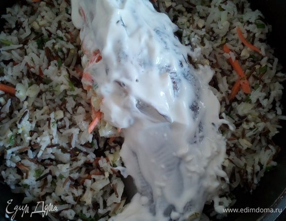 В центр глубокой сковороды выкладываем рыбу. Вокруг рыбы выкладываем рисово-овощную массу. Рыбу смазываем сметаной, солим. Добавляем 0,5 стакана воды. Накрываем сковороду крышкой и тушим 15 — 20 минут.