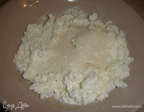 Приготовим начинку. Финики залить теплой водой на 10 минут. В тарелку выложить мягкий творог, всыпать сахар.