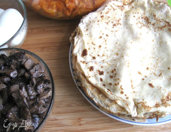 Испечь блины. 
Смешать муку и 3/4 стакана молока венчиком, добавить оставшееся от общего количества молоко, яйца, соль, сахар, перемешать. Испечь блины, смазав раскаленную чугунную сковороду оливковым маслом для каждого блина. Во время приготовления готовые блины держать на водяной бане, смазывая сливочным маслом. Снять с водяной бани миску с блинами, дать остыть.