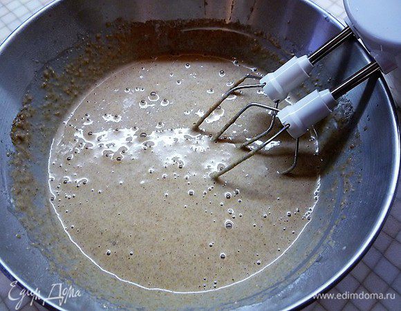 Добавляем растопленное сливочное масло, энергично взбиваем 1 минуту, накрываем чашку с тестом полотенцем и оставляем на 2 часа.