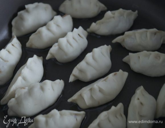 Обжарить нижнюю сторону пельменей до золотистой корочки на разогретой с растительным маслом сковороде. 