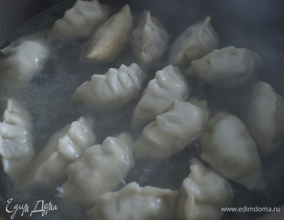 Влить воду, почти полностью закрывая пельмени и тушить под закрытой крышкой до готовности, пока почти вся вода не выпарится.