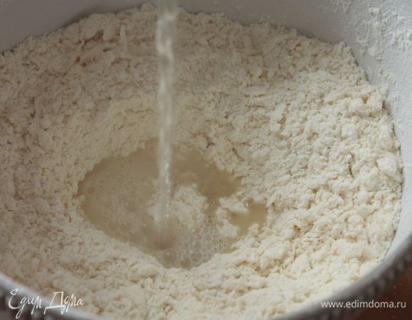 Важные примечания:
1. Из указанного количества ингредиентов у меня получается 30 — 32 шт. хинкали (изначально я вырезаю круги диаметром 12 см).
2. Фарш также используйте на ваш вкус. Я обычно делаю два вида: свинина-говядина и баранина.
Просейте муку вместе с солью. Влейте в муку два яйца и тщательно разотрите мучную смесь с яйцами до образования крошки. 
Сделайте в мучной крошке углубление и влейте 250 мл кипятка. И сразу же начинайте замешивать тесто! Я предпочитаю использовать деревянную или силиконовую лопатку, так как тесто поначалу очень горячее.