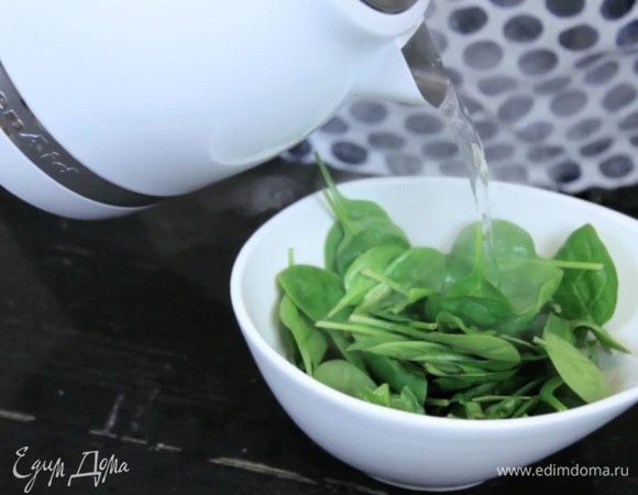 Залить шпинат кипятком и дождаться, пока вода немного остынет. Затем слить ее и хорошо отжать шпинат.