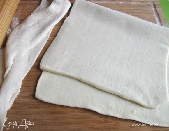 Тесто достать из морозильной камеры, дать ему постоять при комнатной температуре. Я использовала готовое слоеное дрожжевое тесто и не пожалела об этом. Оно прекрасно держало начинку, вместе с тем по сравнению с обычным дрожжевым тестом, оно менее тяжелое.
