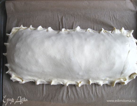 Положить сверху блинов тесто, защипнуть края. Духовку разогреть до 200°С.