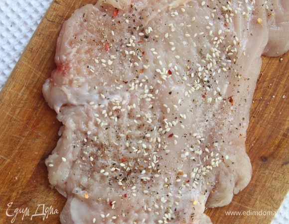 Котлету посолить и поперчить по вкусу и присыпать кунжутом с одной стороны (тоже самое проделываем со второй отбивной).