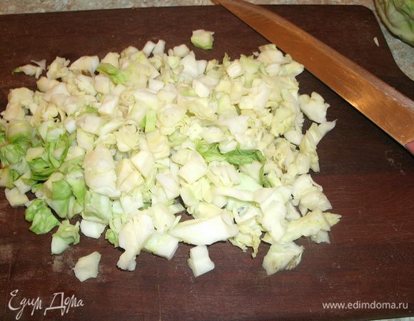 Без огорода мои родители не представляли жизни семьи. И потому овощи всегда были на столе. Капусту в пельмени добавляли не только потому, что так было принято в Удмуртии, а еще из экономии — кочанов в подполье хранилось невиданное для нас, детей, множество. А про пользу от овощей и наши бабушки-дедушки постоянно говорили. 
Капусту для начинки режем мелкими кубиками. Слегка обминаем, чтобы капуста стала мягче и выделила сок.
Раньше капусту рубли в корыте сечкой, и она была очень сочная, вкусная.   