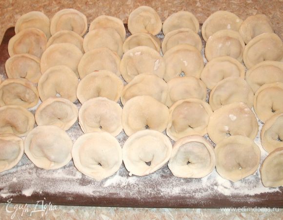 На каждый кружок кладем начинку и залепляем его сначала полукругом, а потом слепляем концы. Выкладываем пельмени на посыпанную мукой доску. 
После того, как сочень раскатан, сочешки вырезаны, к лепке приступали остальные члены семьи. Несколько тарелок с фаршем и каждый занят делом. :) А между делом — разговоры о том, о сем.  
Сейчас мы часто стряпаем пельмени впрок, налепим, а потом морозим в морозилке. А тогда мы ели пельмени практически без заморозки, свежестряпанными. 