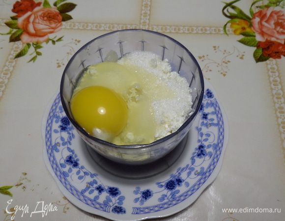 Готовим творожную добавку. В чашу блендера выкладываем 170 г творога «Домик в деревне», 1 яйцо, 50 г сахара и 1 ст. л. крахмала.