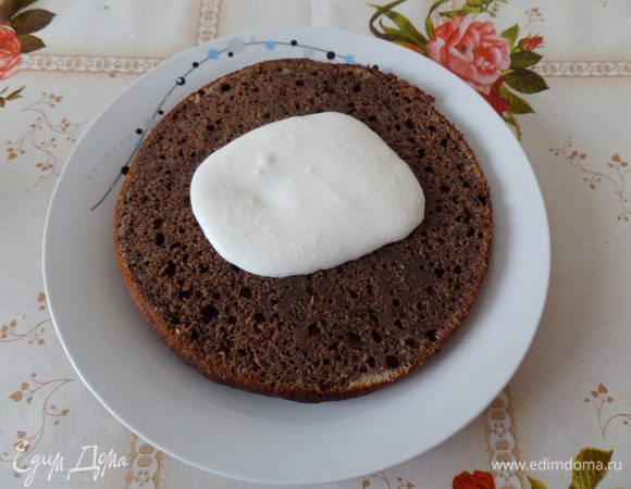 На блюдо выкладываем корж. Поверх коржа выкладываем 2 — 3 ст. л. крема. Равномерно распределяем. 