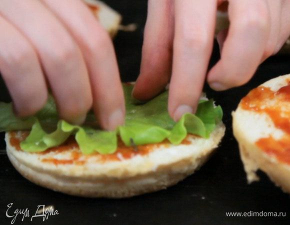 Выложить на нижнюю булочку лист салата.