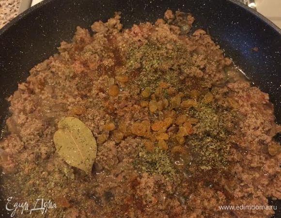 Затем добавить лавровый лист, паприку, соль, черный перец, майоран, изюм и перемешать.