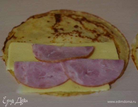 На половину блина выкладываем начинку: сыр (можно пластинами, можно на терке измельчить), ветчину. На ветчину снова сыр.