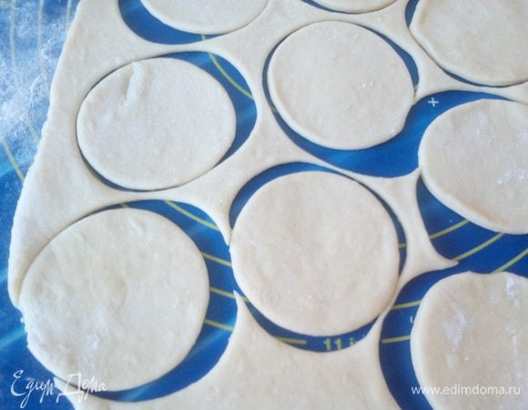 Тесто делим на 3 — 4 части, так удобнее работать. Каждую часть раскатываем в пласт. Стаканом вырезаем кружки. 