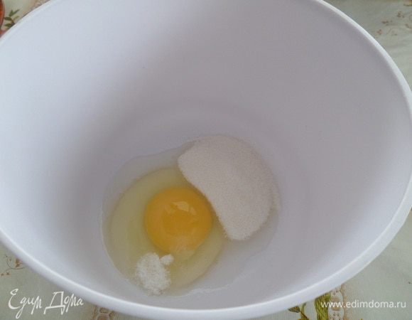 В чашку выкладываем куриное яйцо, соль, сахар. Взбиваем с помощью миксера.