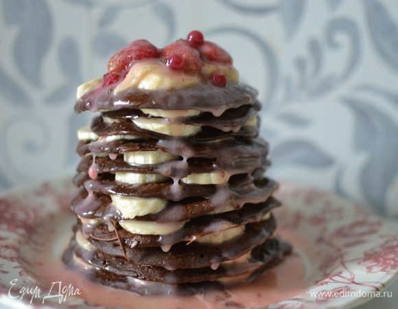 Бананы нарезать кружочками, подавать шоколадные оладьи с кусочками бананов, полив карамельным соусом и посыпав ягодами, орехами (по вкусу).