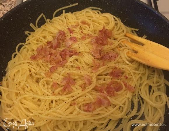 Готовые спагетти переложить на горячую сковороду, где жарился бекон, перемешать. Затем добавить бекон.