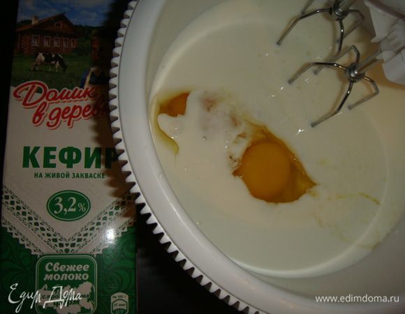 В посуду для взбивания влить кефир «Домик в деревне», добавить яйца, соль и сахар, перемешать.