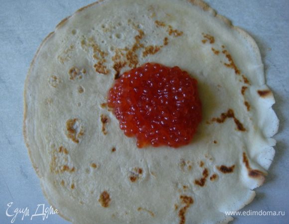 Я сделала мешочки с красной икрой, перевязав их перышком зеленого лука.