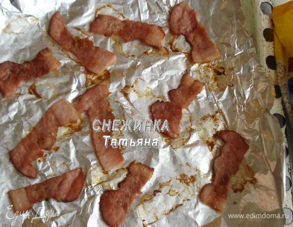 Полоски грудинки или бекона раскладываем на фольгу, которую кладем на противень. Ставим в разогретую до 200°С духовку подрумяниться на 5 — 7 минут. Один раз нужно перевернуть. Снимаем с фольги.