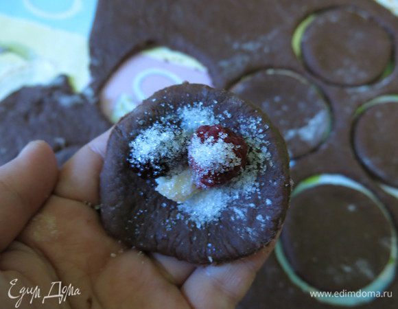 Кладем в центр круга по ягоде, кусочку шоколада, насыпаем сахар. На один вареник — 1/4 чайной ложки сахара.